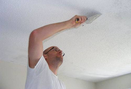 Îndepărtarea spălăturii albe din tavan cu o spatulă