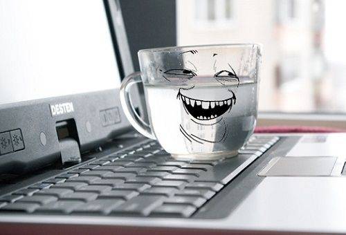 un pahar cu apă pe un laptop