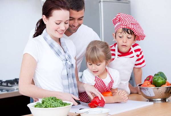 Familia în bucătărie pregătind o salată