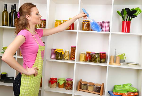 Fata aranjează rafturi cu alimente