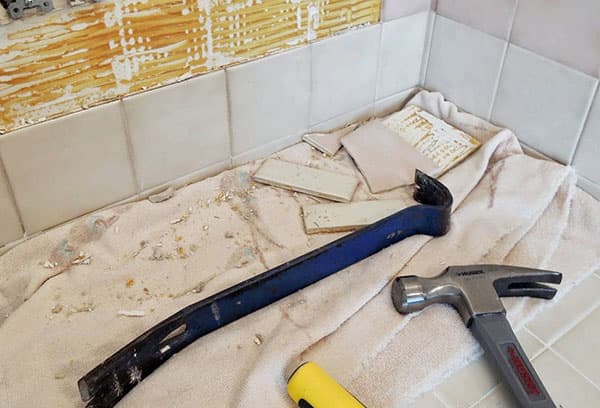 Procesul de demontare a plăcilor vechi din baie