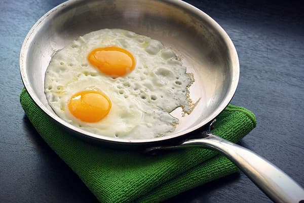 Ouă prăjite într-o tigaie din aluminiu