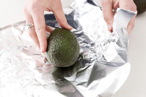 Femeia înfășoară avocado în folie