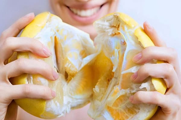 Fată cu un pomelo copt