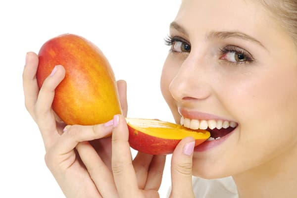 Fată mâncând mango