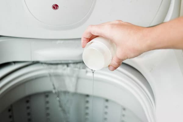 Adăugând detergent lichid la tambur