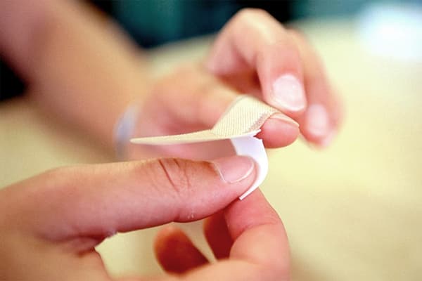 Το κορίτσι σφραγίζει ένα δάχτυλο με ένα βοήθημα ζωνών