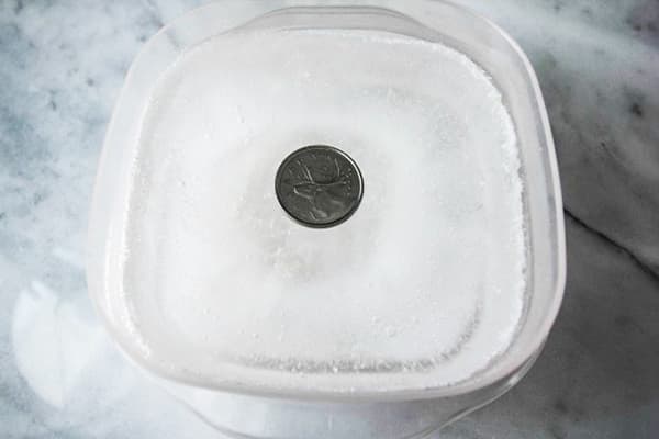 Moneda într-un recipient cu gheață