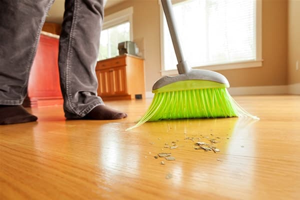 Un bărbat care mătura podeaua