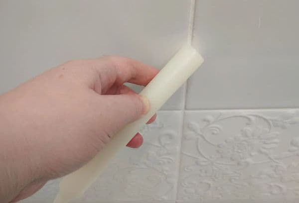 Cum curățați cusăturile dintre plăci de murdărie și mucegai cu o lumânare cu parafină