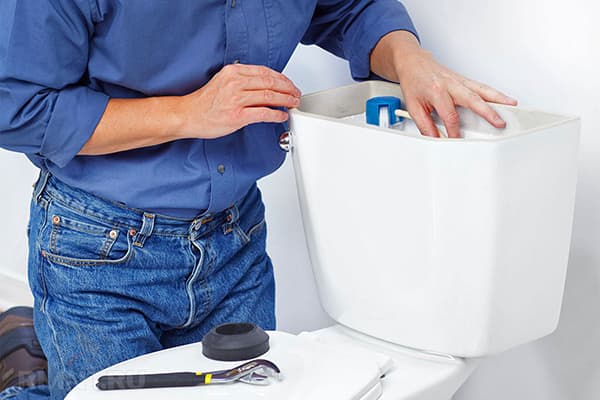 Instalator care fixează un vas de toaletă